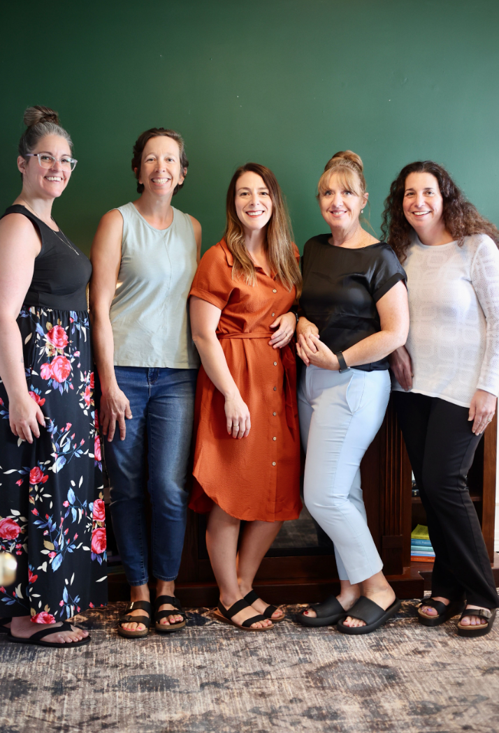 Counsellers from Curan Counselling against a green wall.