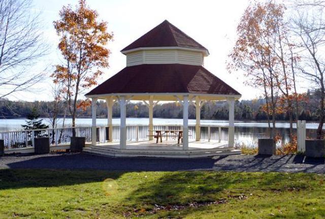 A gazebo during golden hour in front of a lake.