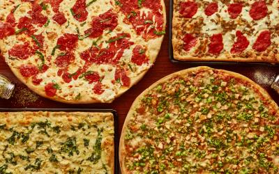 A flatlay of four different kinds of pizza from Alexandra's Pizza.