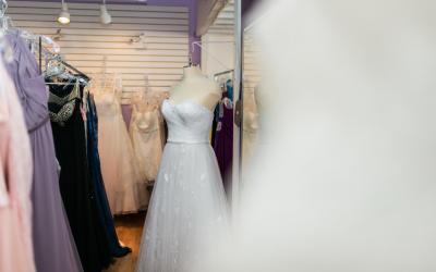 Formal dresses hung up in store.