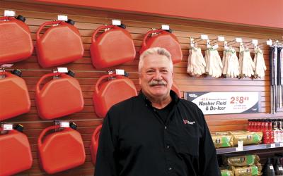Man standing in front of red gas cans.