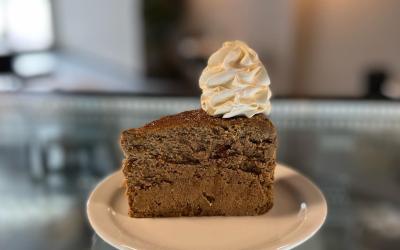 A slice of cheesecake on a plate with a dollop of whipped cream on top.