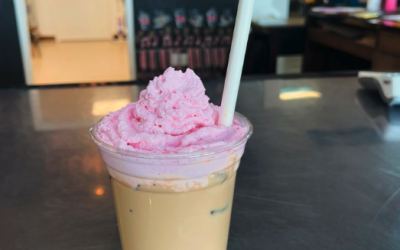 An iced coffee with pink whipped cream