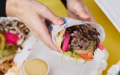 Someone holding a shawarma.